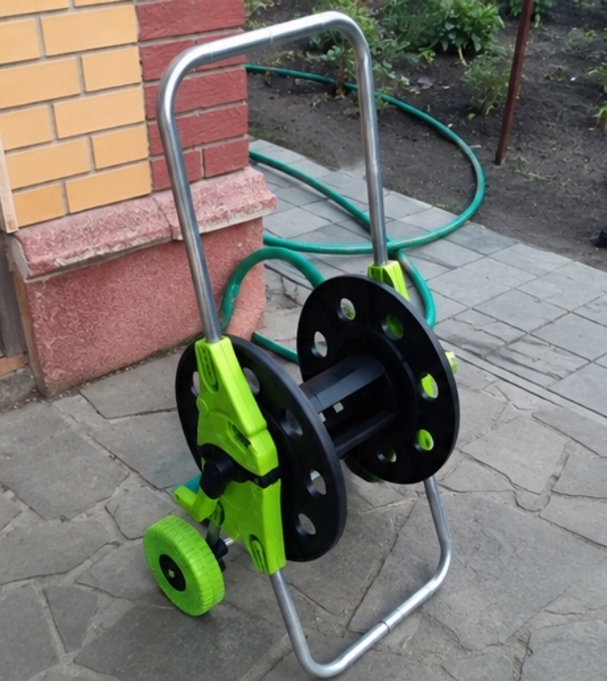 Візок-котушка зі шлангом у дворі приватного будинку, домашнє фото